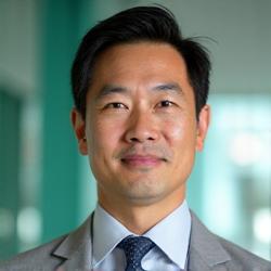 Dr. Robert Chen, an East Asian man in his early 50s, distinguished and thoughtful, with a subtle smile.